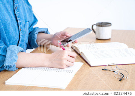 Young woman studying with a smartphone [Parts cut] 82324476