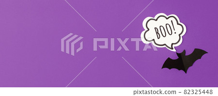 Halloween bats decorations and chat bubble boo on purple background. Flat lay, top view, minimal style, copy space, banner for your site, party invitation, flyer, traditional color Halloween bats decorations and chat bubble boo on purple background. Flat lay, top view, minimal style, copy space, banner for your site, party invitation, flyer, traditional color 82325448
