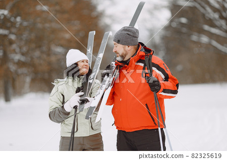 Senior couple skiing cross-country in a forest 82325619