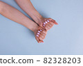 Perfect pink manicure gel art polish hands woman closeup on isolated background. 82328203