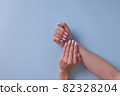 Closeup of hands of a young woman with pink manicure. 82328204