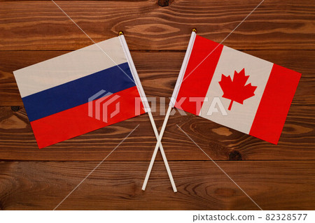 Flag of Russia and flag of Canada crossed with each other. The image illustrates the relationship between countries. Photography for video news on TV and articles on the Internet and media. Flag of Russia and flag of Canada crossed with each other. The image illustrates the relationship between countries. Photography for video news on TV and articles on the Internet and media. 82328577