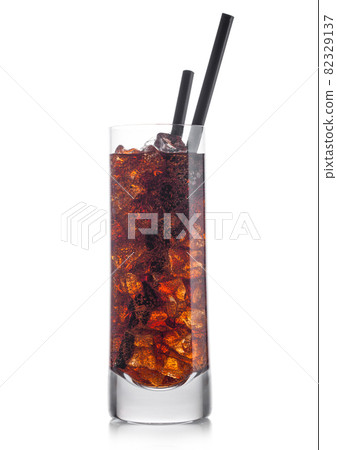 Cuba Libre Cocktail in highball glass with ice cubes and black straw on white. 82329137