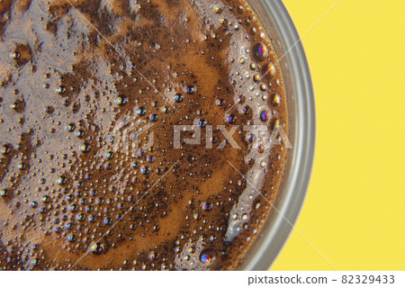 freshly brewed coffee in a Cup on yellow background close up 82329433