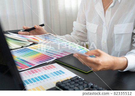 creative graphic designer choosing color scale for editing artwork while working in office. 82335512
