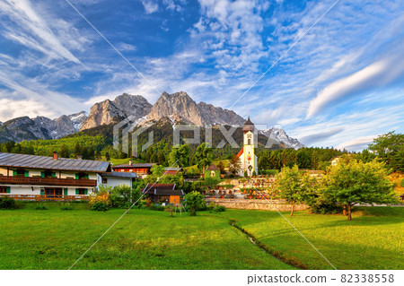 Garmisch Partenkirchen Germany, Zugspitze peak and Alps mountain range with small church in Grainau village 82338558