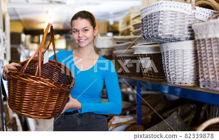 female purchaser standing with picnic basket 82339878