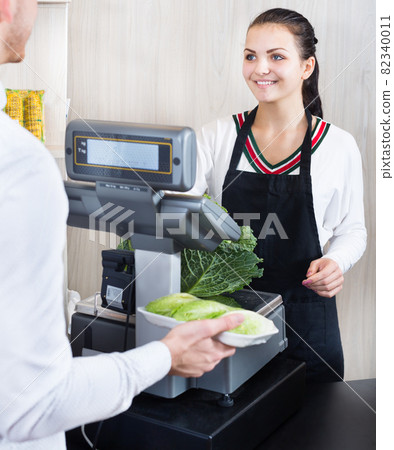 Female seller assisting customer in grocery shop 82340011