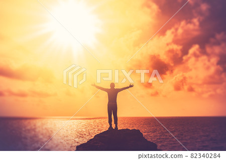 Copy space of happy man hand raise on top mountain at tropical beach and sunset sky abstract background. 82340284