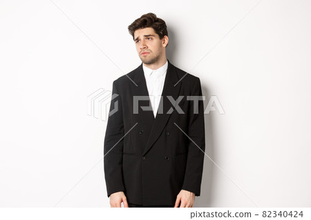 Image of tired man in suit looking left with distressed, gloomy expression, stare left at copy space, standing exhausted over white background Image of tired man in suit looking left with distressed, gloomy expression, stare left at copy space, standing exhausted over white background 82340424
