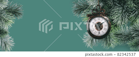Christmas ornaments clock on green branch background Christmas ornaments clock on green branch background 82342537