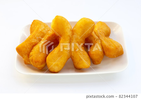Deep-fried dough sticks or chinese bread sticks on white background. Deep-fried dough sticks or chinese bread sticks on white background. 82344107