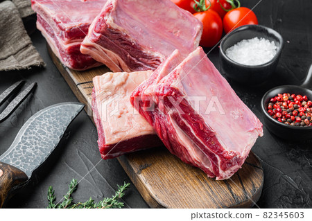 Raw meat ribs, with ingredients , on black stone background 82345603
