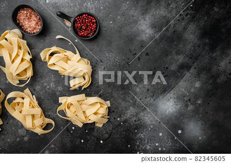 Pasta ingredients, on black dark stone table background, top view flat lay, with copy space for text 82345605