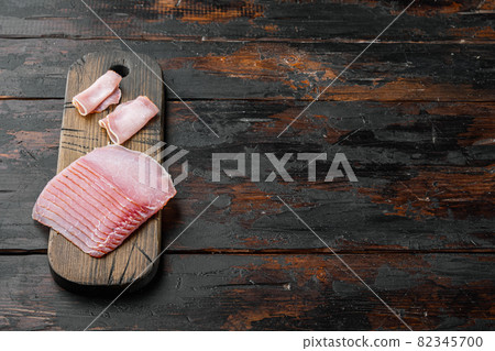 Curled Slices of Prosciutto, on old dark wooden table background, with copy space for text 82345700
