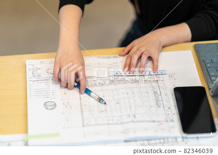 Female first-class architect checking furniture layout 82346039