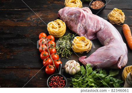 Raw rabbit meat and cooking ingredients stew tagliatelle, on old dark wooden table background, with copy space for text 82346061