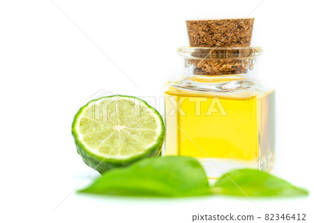 Bergamot essential oil in a small square glass bottle with cork, fresh bergamot fruit, and green leaf on white background. Blank space on the bottle for label design branding. Bergamot essential oil in a small square glass bottle with cork, fresh bergamot fruit, and green leaf on white background. Blank space on the bottle for label design branding. 82346412