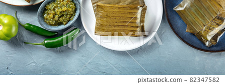 Tamal overhead flat lay panorama with copy space. Traditional Mexican dish Tamal overhead flat lay panorama with copy space. Traditional Mexican dish 82347582