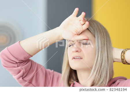 Portrait of young tired woman with headache closeup Portrait of young tired woman with headache closeup 82348194