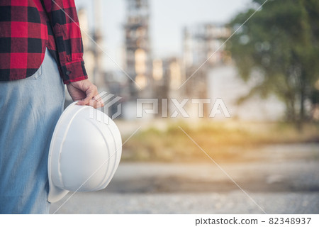 Refinery woman engineer oil industry hands hold worker helmet hard hat. Refinery industry engineering. Engineer woman hands holding hardhat white work helmet hard hat for Construction Engineering Refinery woman engineer oil industry hands hold worker helmet hard hat. Refinery industry engineering. Engineer woman hands holding hardhat white work helmet hard hat for Construction Engineering 82348937