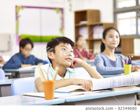 asian elementary school boy listening to teacher attentively in class asian elementary school boy listening to teacher attentively in class 82349680