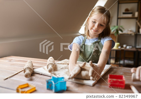 Little girl works with forms for clay at the table 82349967