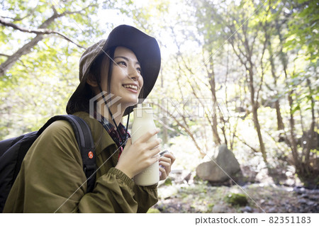 Female solo camp trekking image with a drink and a break 82351183