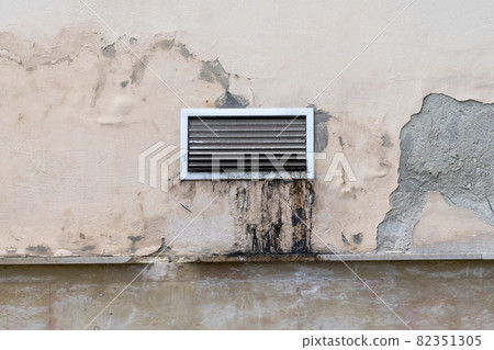 Dirty greasy exterior ventilation grill with dirt streaks on a peeled old cement restaurant wall. Unclean air conditioning system grate for technical service maintenance Dirty greasy exterior ventilation grill with dirt streaks on a peeled old cement restaurant wall. Unclean air conditioning system grate for technical service maintenance 82351305