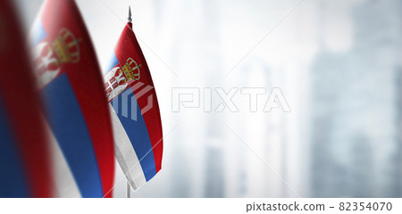 Small flags of Serbia on a blurry background of the city 82354070