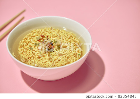 Chopsticks holding instant Asian noodles with natural light 82354843