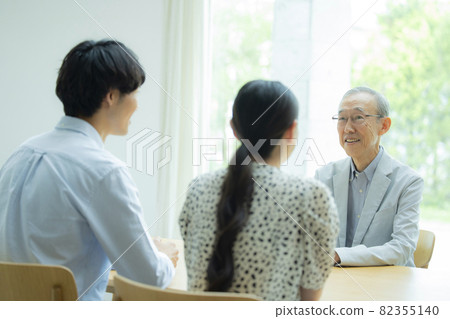 Senior man and young couple talking 82355140