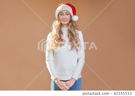 Woman christmas Sants Hat sweater peach studio background 82355533