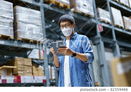 New Normal Asian men, staff, product wearing face mask. counting Warehouse Control Manager Standing, counting and inspecting products in the warehouse 82359466