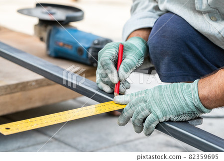 man measures metal with a ruler for cutting 82359695