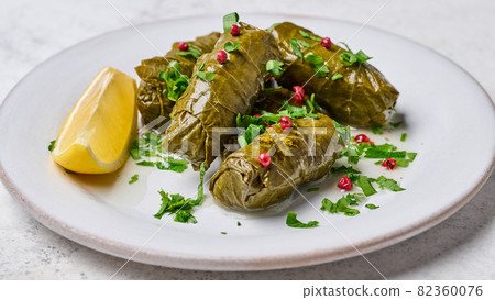 Macro dolma, stuffed grape leaves with rice, meat, parsley, pepper and lemon Macro dolma, stuffed grape leaves with rice, meat, parsley, pepper and lemon 82360076
