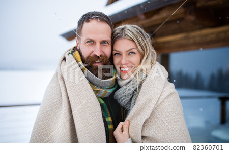 Portrait of happy mature couple in love enjoying holiday in mountain hut, standing outdoors and looking at camera. 82360701