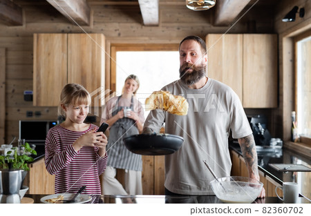 Family with small daughter cooking indoors, winter holiday in private apartment. 82360702