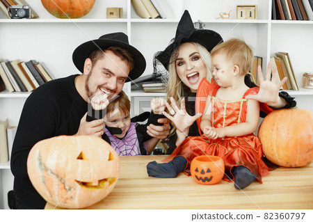 Family in costumes getting ready for halloween at home 82360797