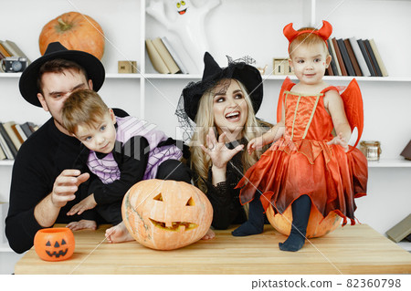 Family in costumes getting ready for halloween at home Family in costumes getting ready for halloween at home 82360798