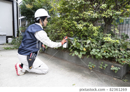 Male landscaping worker spraying pesticide 82361269