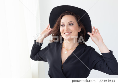 Portrait of a beautiful graceful woman in elegant hat with a wide brim. Beauty and fashion concept. 82361643