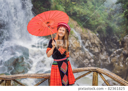 A female tourist dressed in the traditional dress of the inhabitants of the Vietnamese mountains, the Hmong. Woman in Sapa in the fog, Northwest Vietnam. Vietnam travel concept. UNESCO heritage 82361825