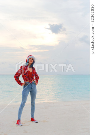 Happy young woman in Santa hat on the beach near the sea. Travel Concept 82362050