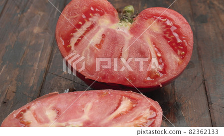 Cutting big ripe tomato in half 82362133