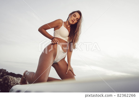Young beautiful sexy woman posing in sea on a SUP board 82362266