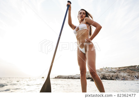 Beautiful model paddlbording relaxing in the sea with clean water Beautiful model paddlbording relaxing in the sea with clean water 82362477