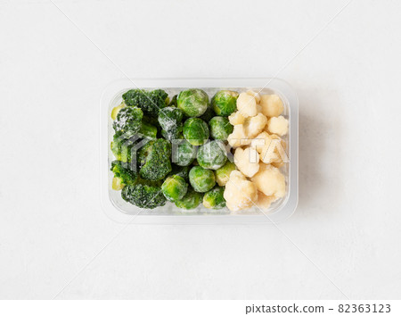 Frozen vegetables. Cabbage set. Broccoli, brussels sprouts and cauliflower in a container on a white background. Top view, flat lay. Frozen vegetables. Cabbage set. Broccoli, brussels sprouts and cauliflower in a container on a white background. Top view, flat lay. 82363123