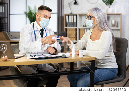 Doctor measuring pulse and oxygen saturation to aged woman Doctor measuring pulse and oxygen saturation to aged woman 82363220