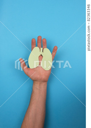 Women's hands hold a paper lungs symbol 82363346